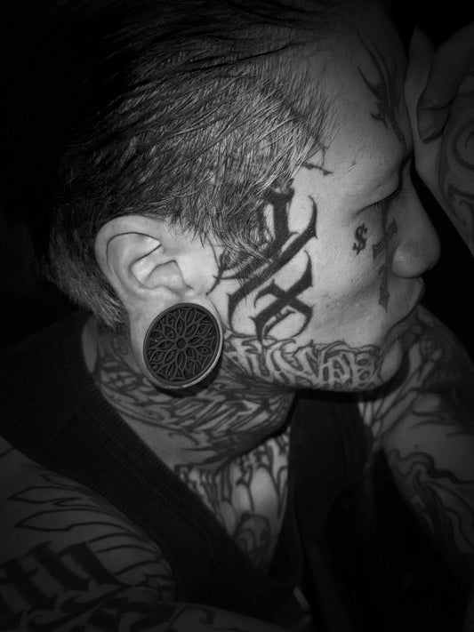 Black and white side profile of a model wearing a Tracery double flared ear tunnel