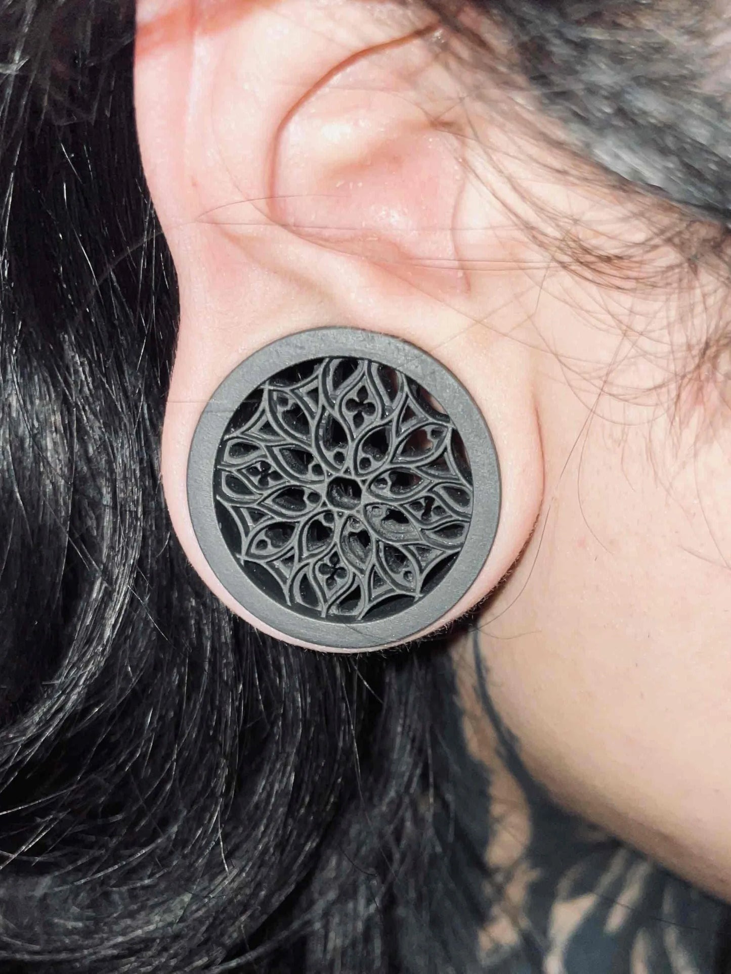 Close-up of an ear wearing a gray Tracery double flared ear tunnel