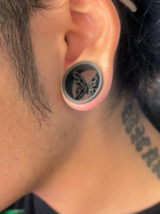 Close-up of an ear wearing a Butterfly double flared ear tunnel