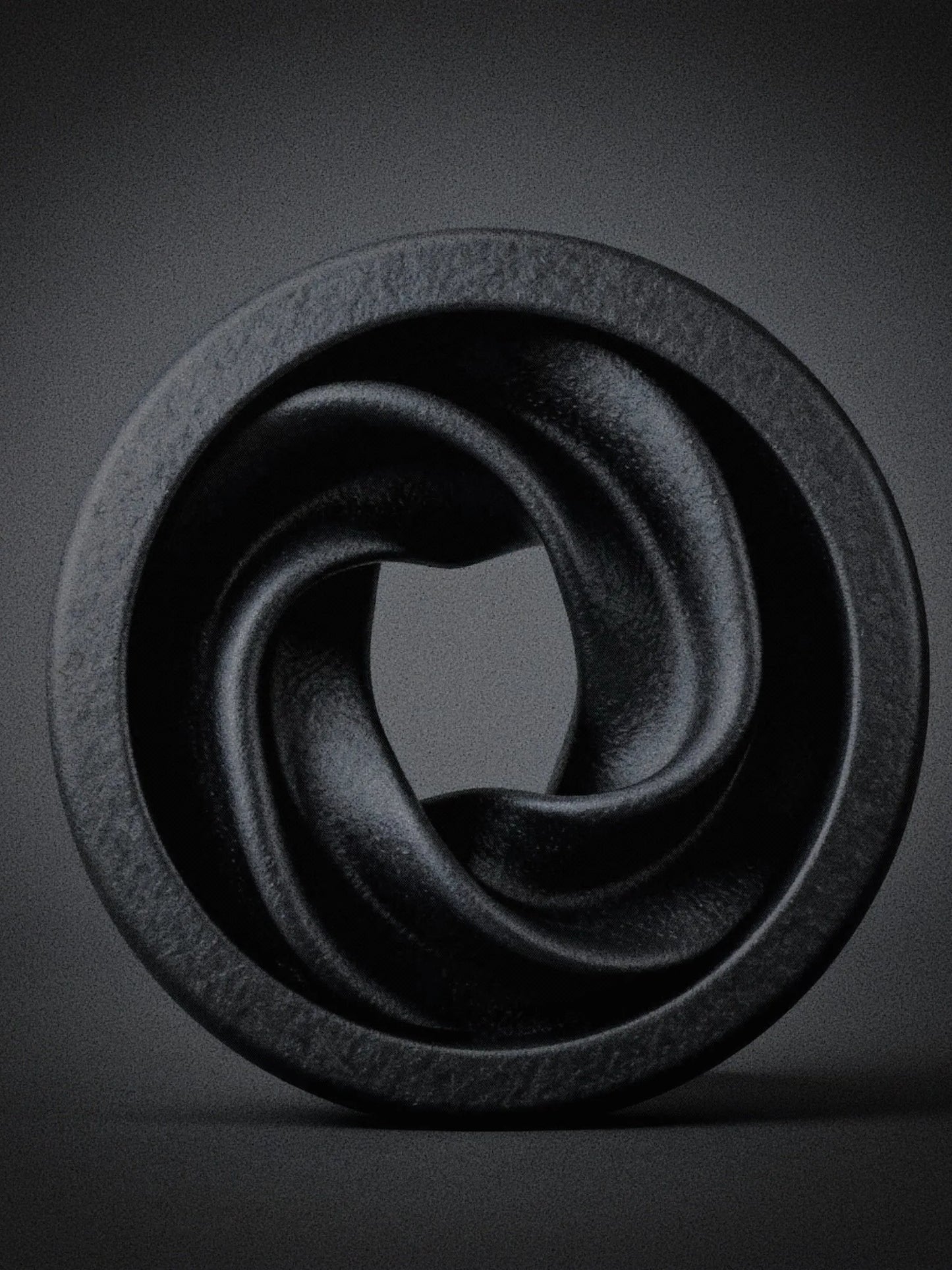 Close-up of a large black Intertwine double flared ear tunnel on a dark background