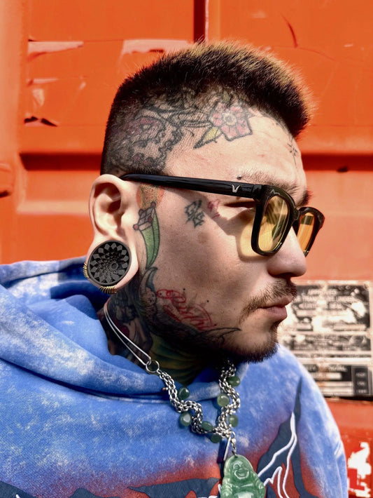 Side profile of a man wearing black Mandala double flared ear tunnels