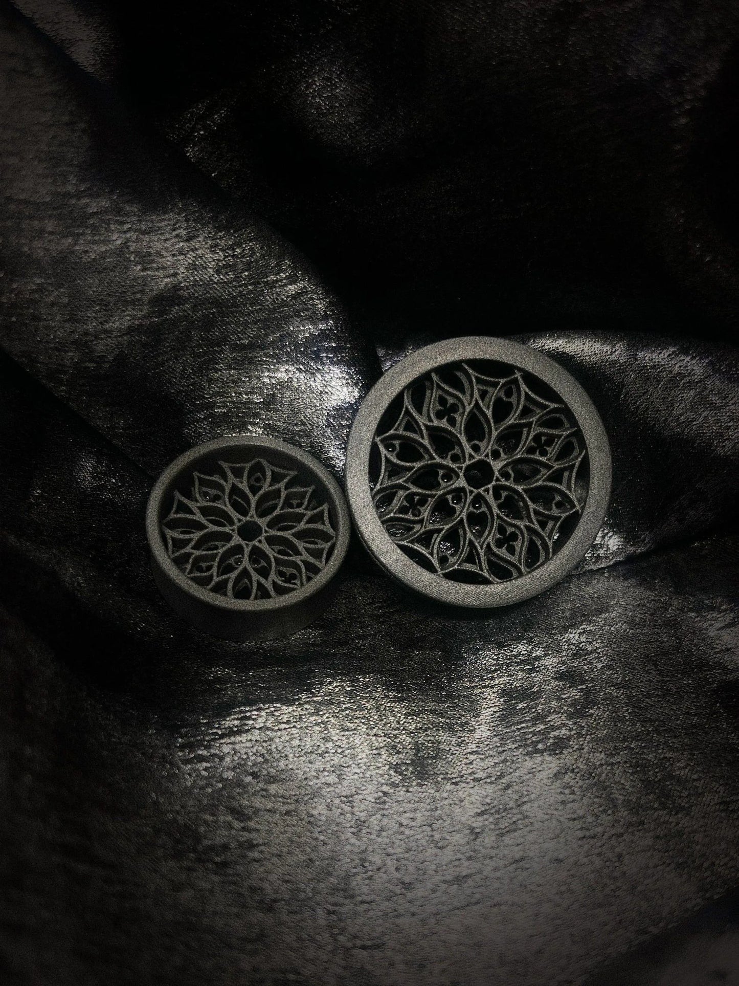Pair of Tracery double flared ear tunnels on a dark textured background