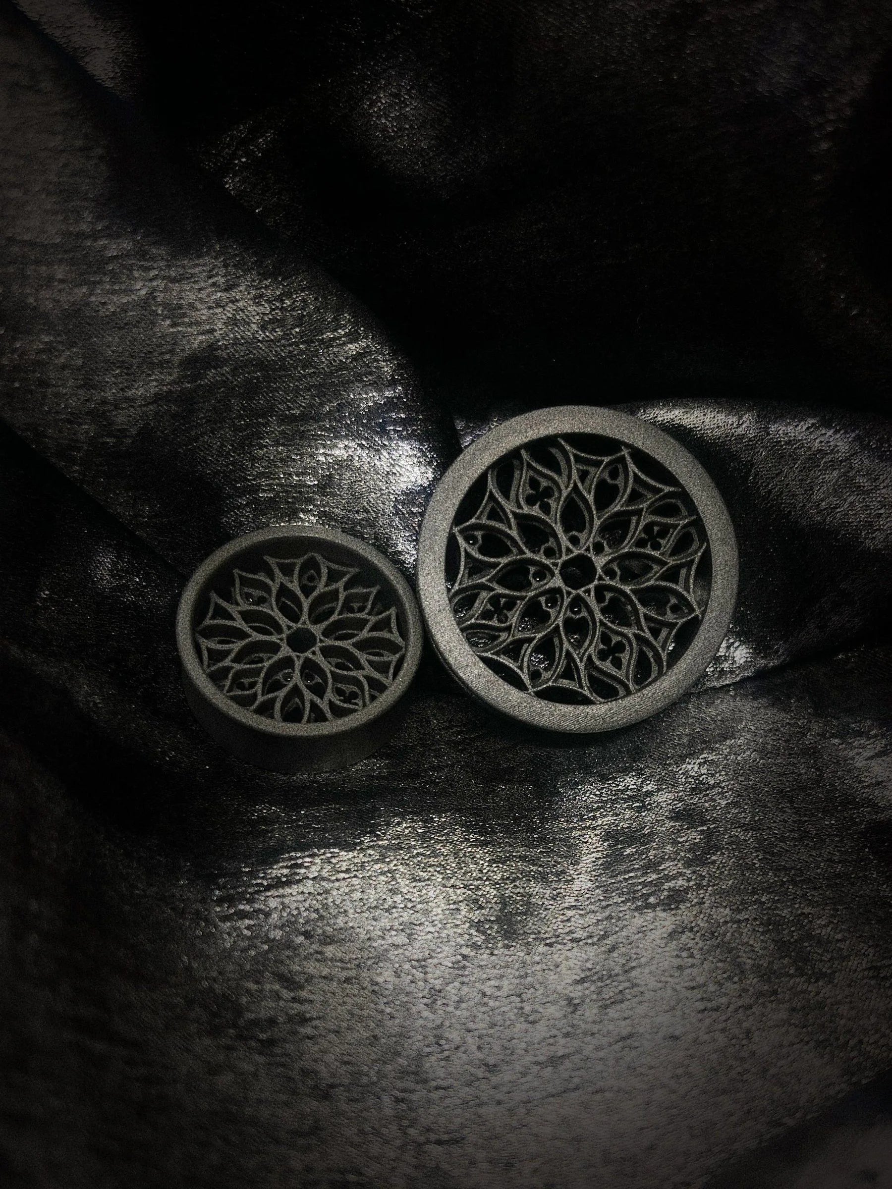 Pair of Tracery double flared ear tunnels on a dark textured background