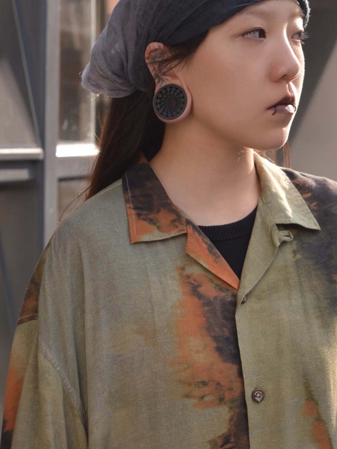 Side profile of a woman wearing black Mandala double flared ear tunnels