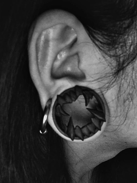 Black and white close-up of an ear wearing a Beast double flared ear tunnel
