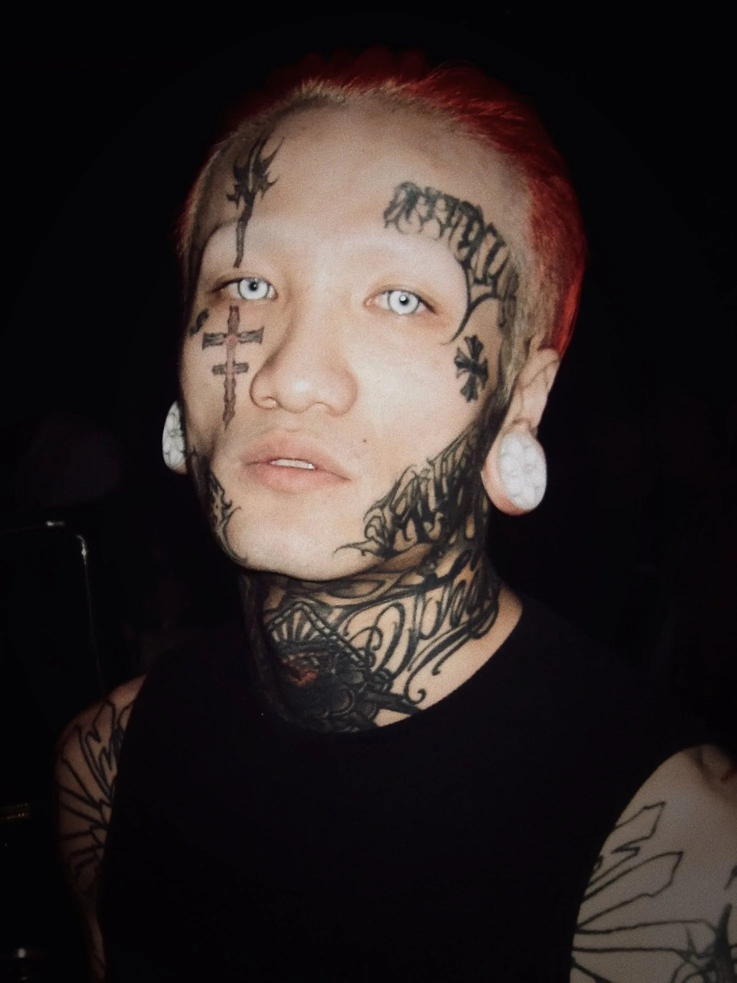Front portrait of a model wearing white Lotus double flared ear plugs