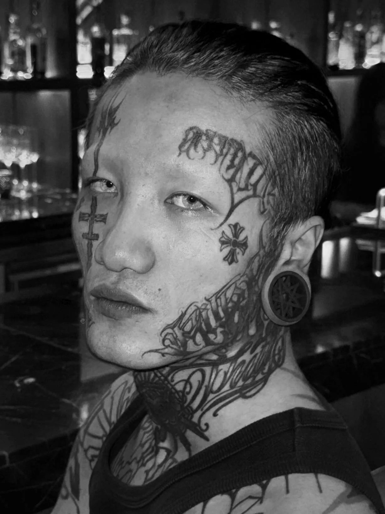 Black and white portrait of a model wearing a Decagram double flared ear tunnel