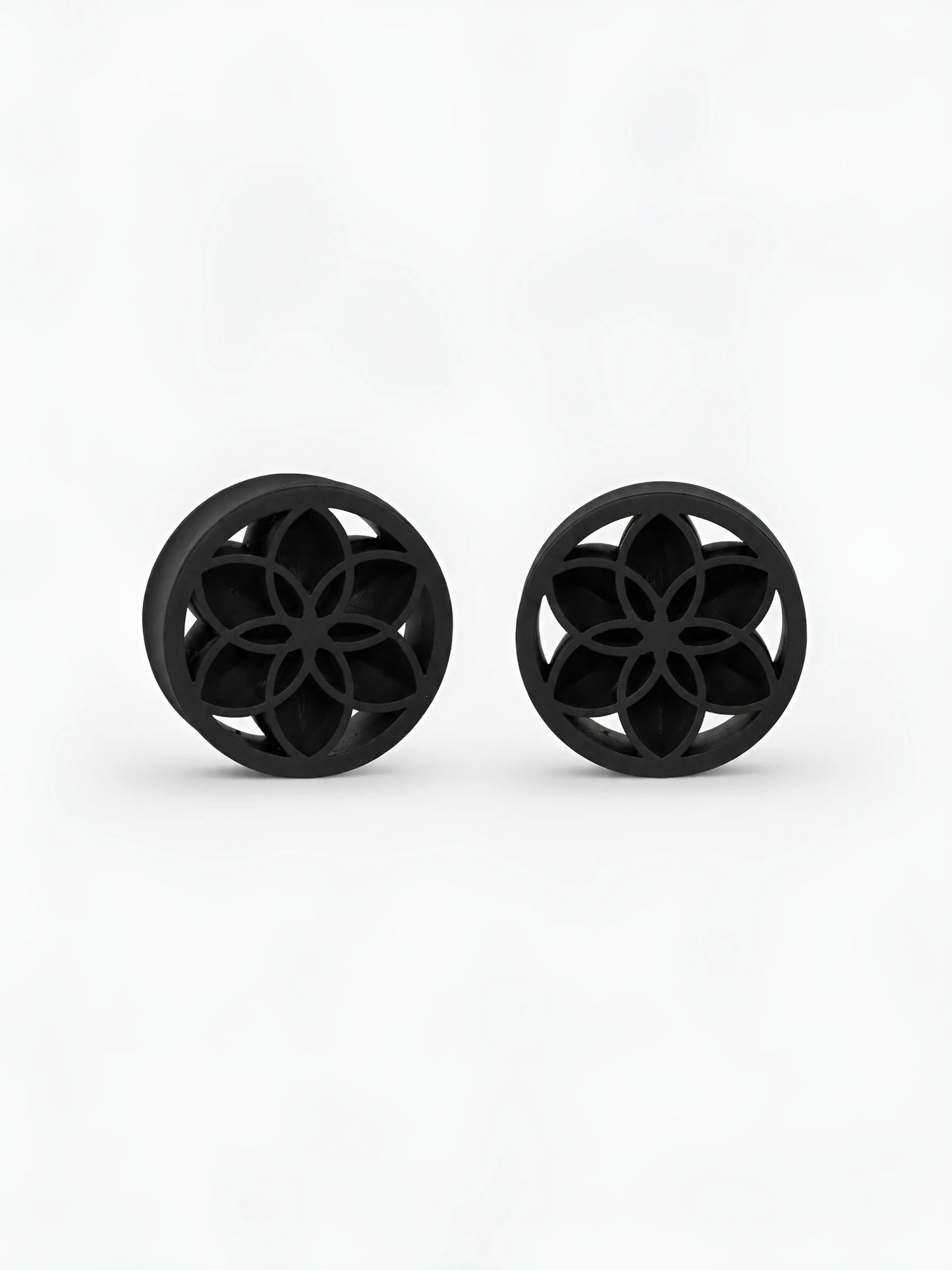 Pair of black Lotus double flared ear plugs on a white background