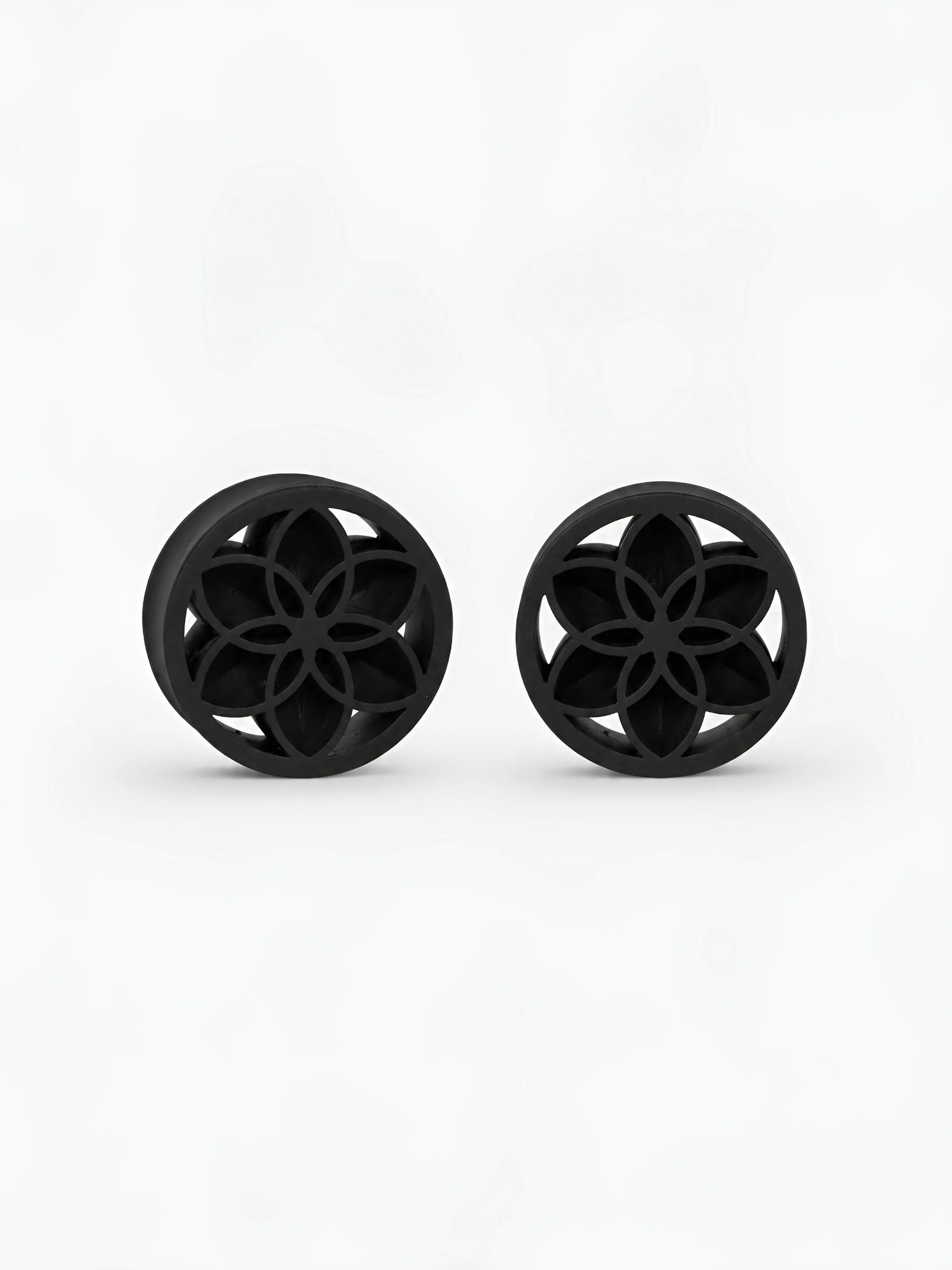 Pair of black Lotus double flared ear plugs on a white background