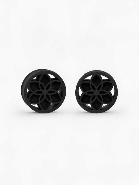 Pair of black Lotus double flared ear plugs on a white background