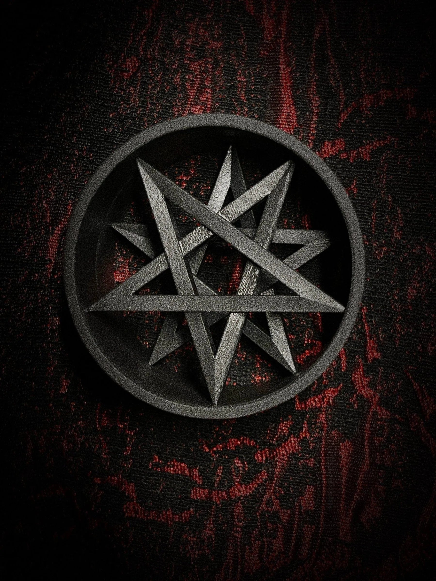 Close-up of a large Decagram double flared ear tunnel on a red and black textured background