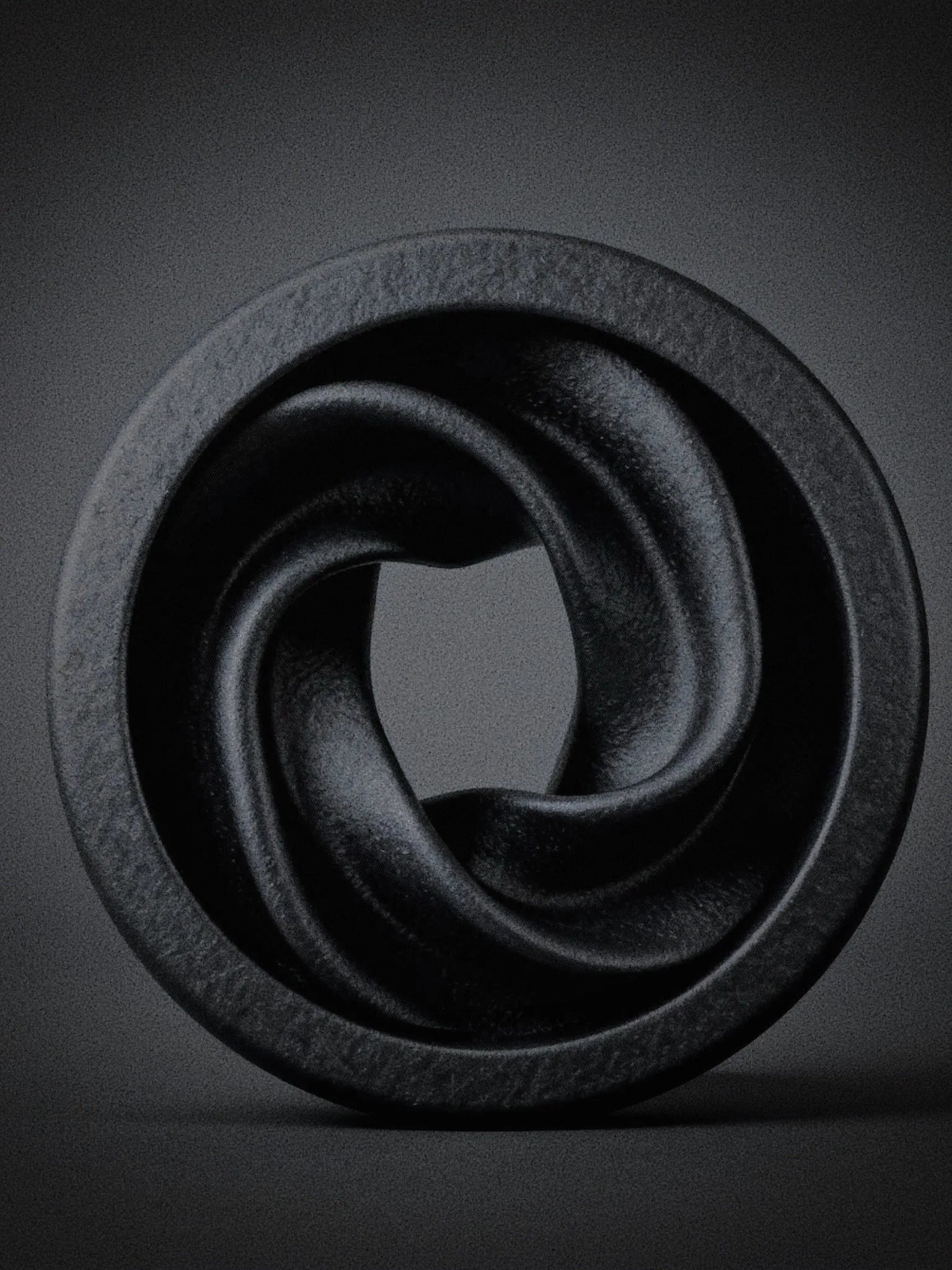 Close-up of a large black Intertwine double flared ear tunnel on a dark background