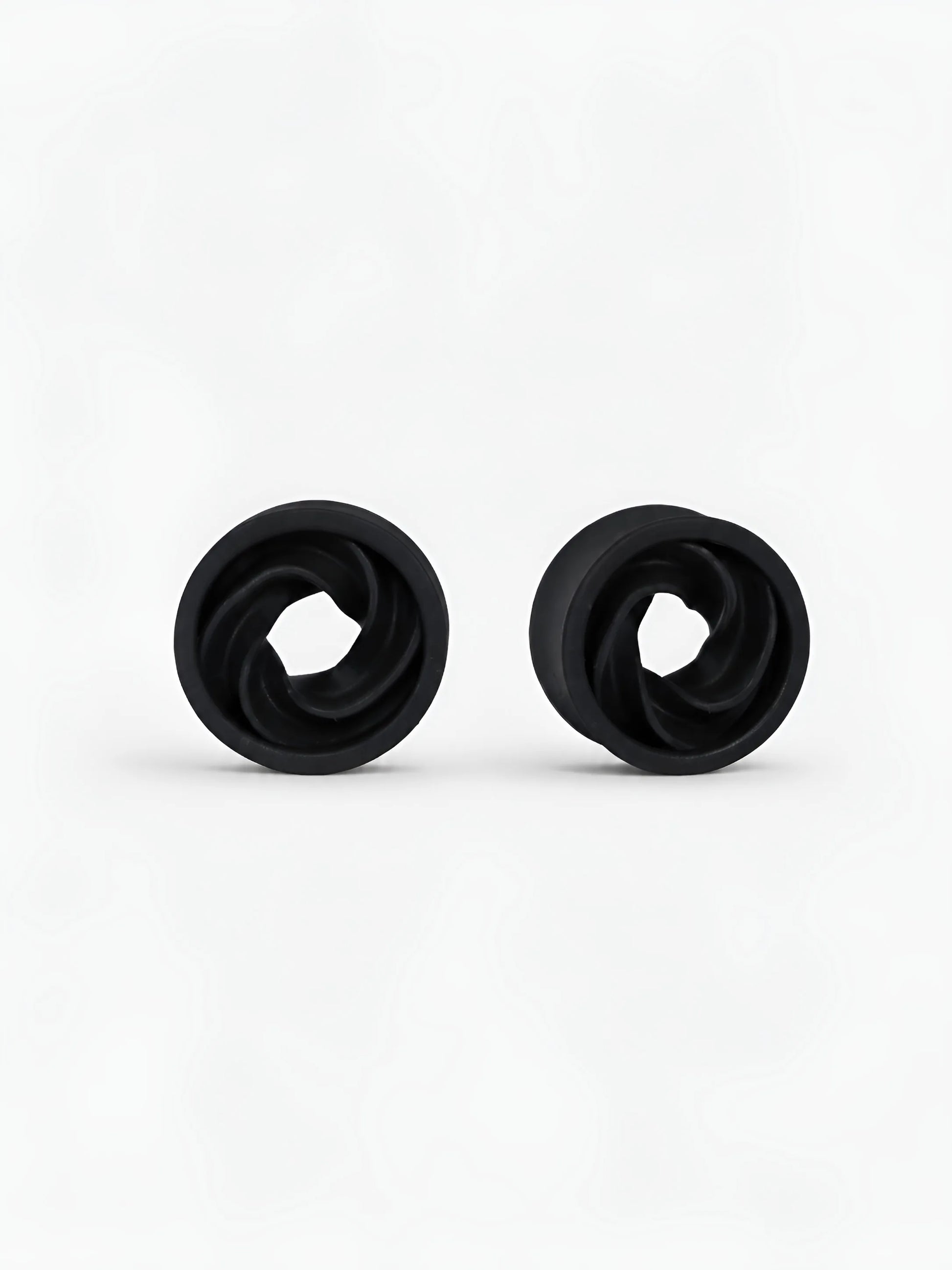 Pair of black Intertwine double flared ear tunnels on a white background